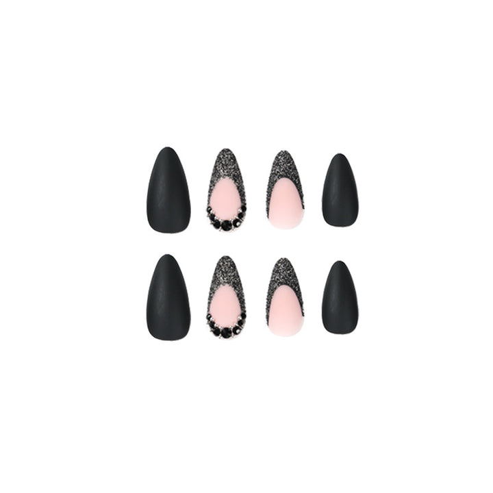 Kunstvolle Stiletto-Nägel mit elegantem Schwarz-Design und Glitzerakzenten Karnz