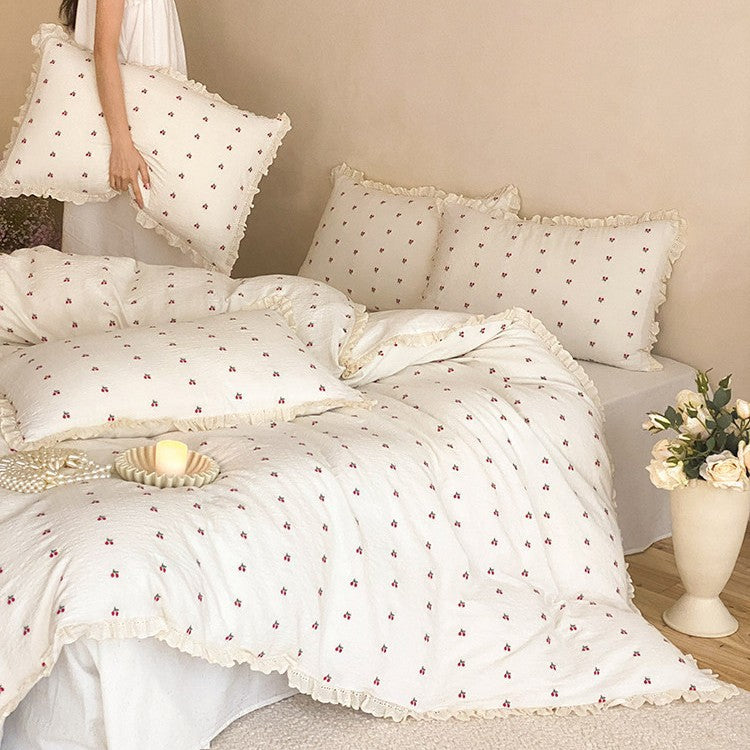 Gestepptes Bettwäscheset aus Baumwoll‑Musselin mit zartem Kirschenprint und Rüschenkante