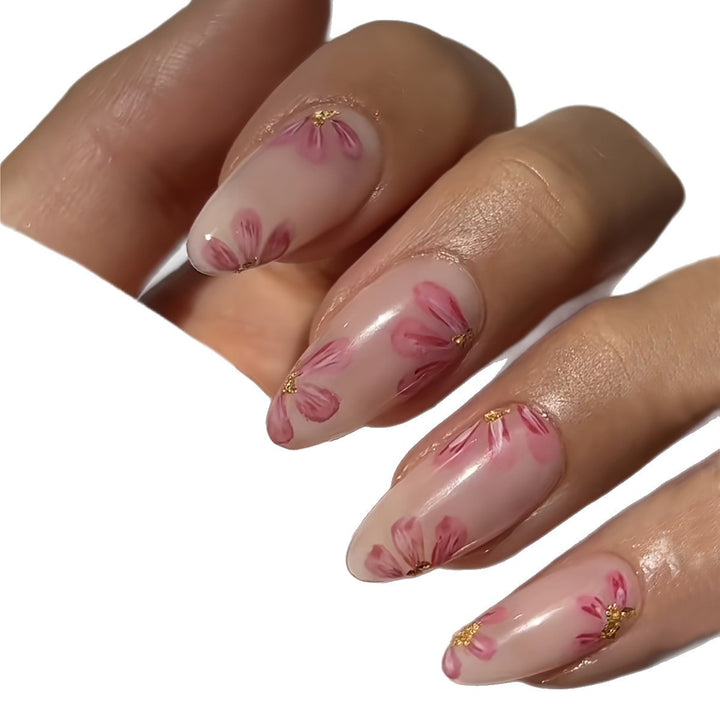 Kunstnagelset mit floralen Akzenten und Goldverzierungen Karnz