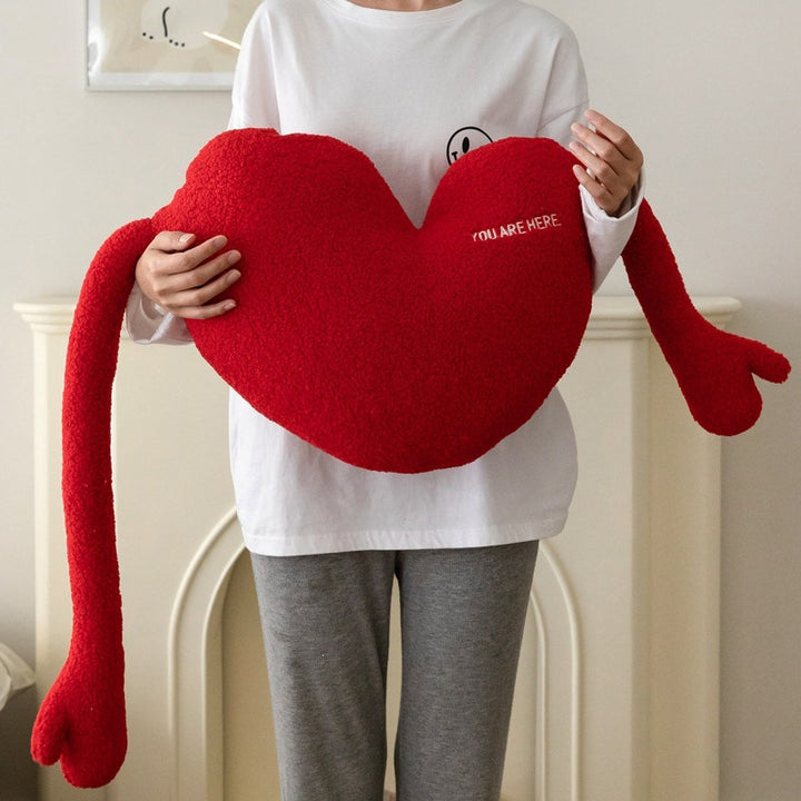 Kuschelkissen in Herzform mit extra langen Armen aus Sherpa‑Fleece und Stickdetail
