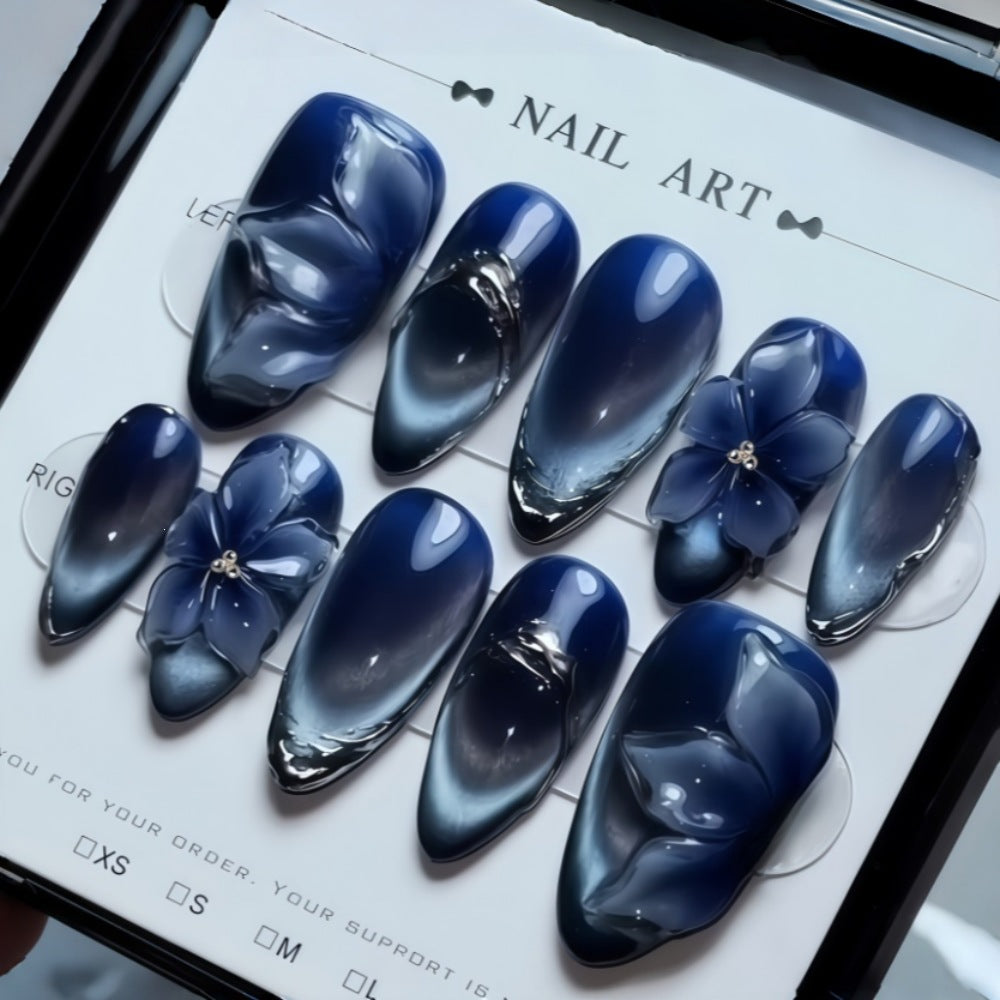 Kunstnagelset mit elegantem blauen Ombre und floralem Design Karnz