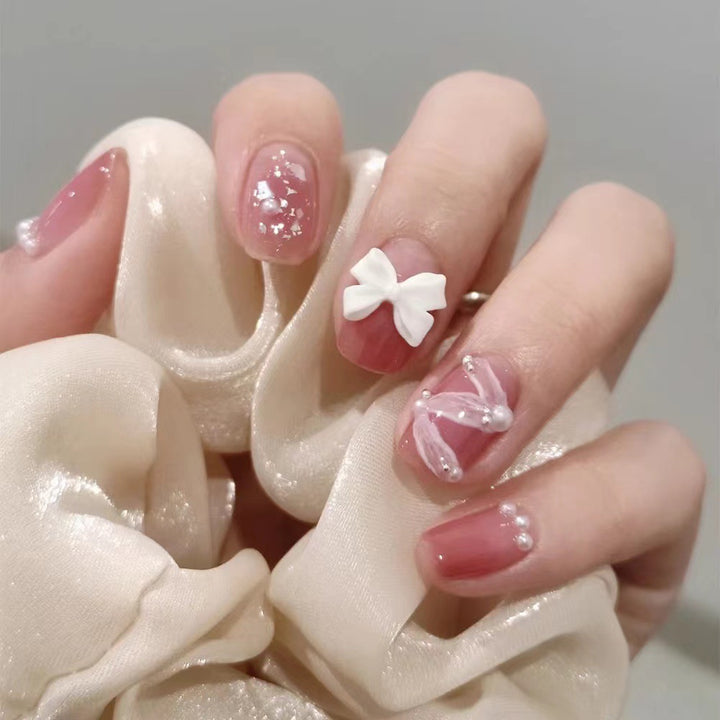 Glamouröse Nagelkunst mit Perlen- und Schleifenakzenten Karnz
