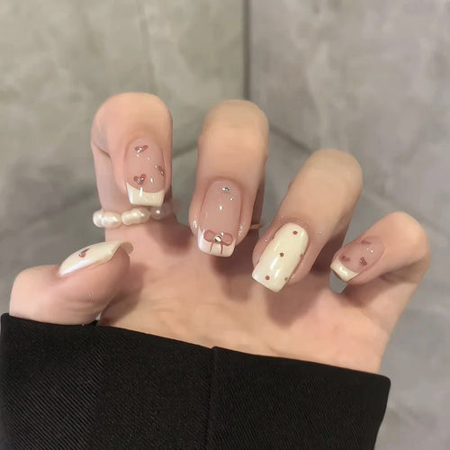 Dekorativer Press-On-Nagelset mit Herz- und Bogenmotiven