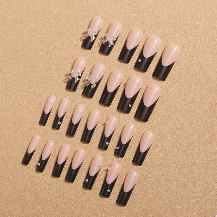 Kunstnagelverzierung mit eleganten Schleifen und Strass Karnz