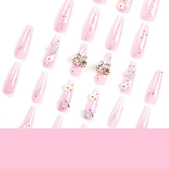 Kunstvolle Nagelverlängerungen mit Glitzer und floralen Akzenten Karnz