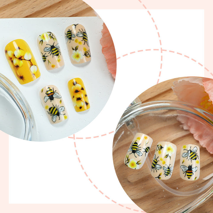 Kunstnagelset mit floralen und bienenmotiven Karnz
