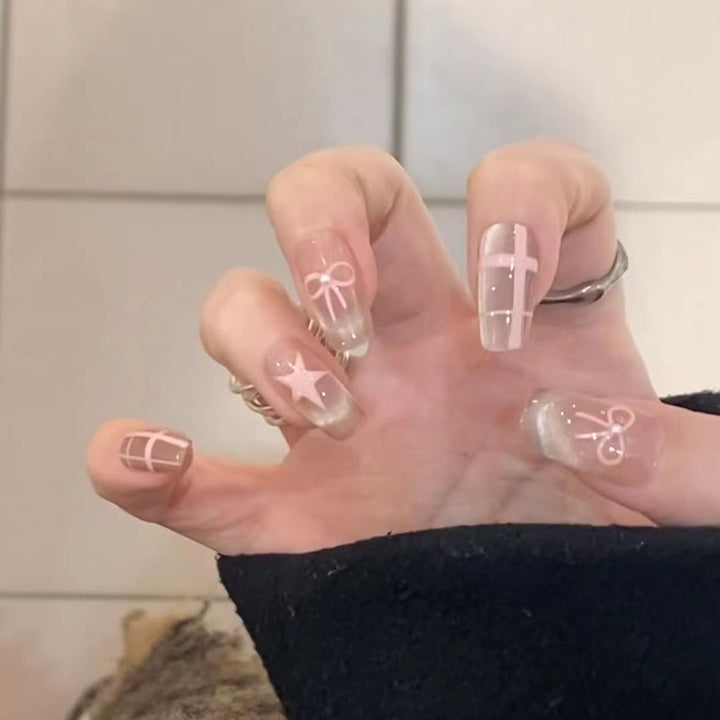 Kunstvolle Acryl-Nägel mit eleganten Schleifen- und Sternmotiven Karnz