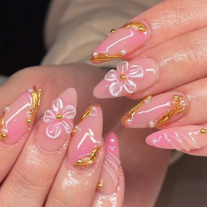 Kreatives Kunstnagelset mit Blumen- und goldenen Akzenten Karnz