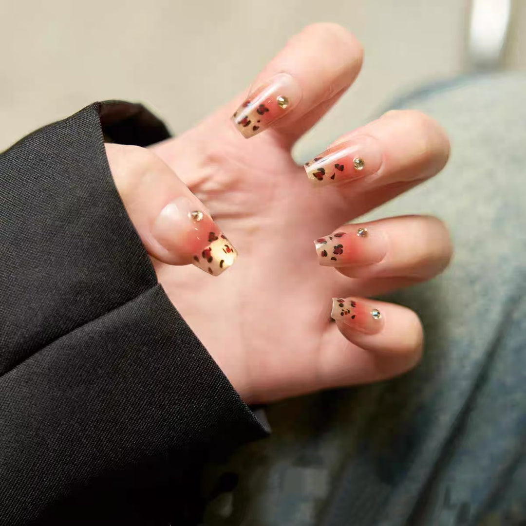 Kunstnägel mit Eleganten Leo-Muster und Glitzerakzenten Karnz