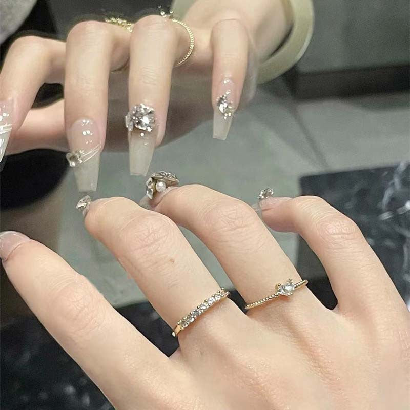 Kunstnagelset mit filigranen Verzierungen und glamurösen Akzenten Karnz