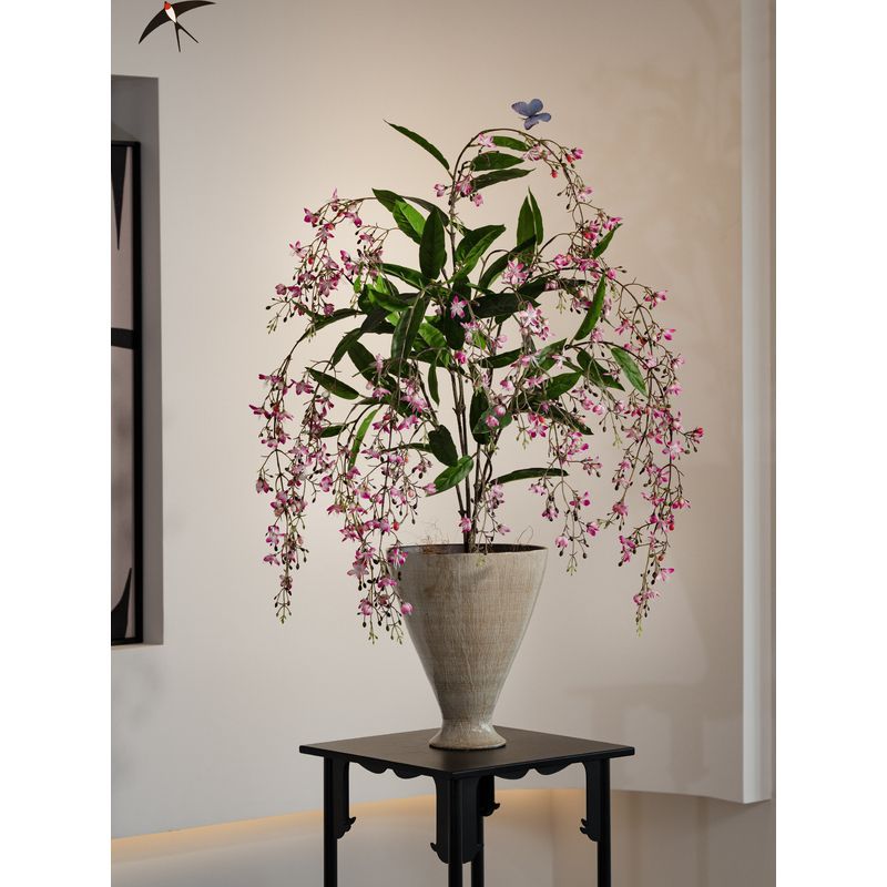 Lebensechte künstliche Blumenarrangement in dekorativem Topf