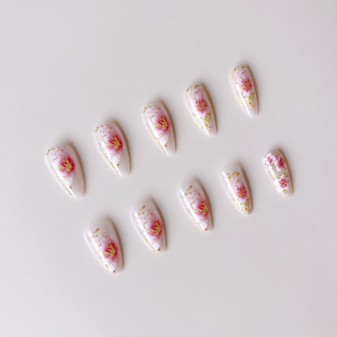 Kunstnägel mit floralen Akzenten und goldenen Details Karnz