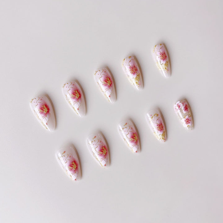 Kunstnägel mit floralen Akzenten und goldenen Details Karnz