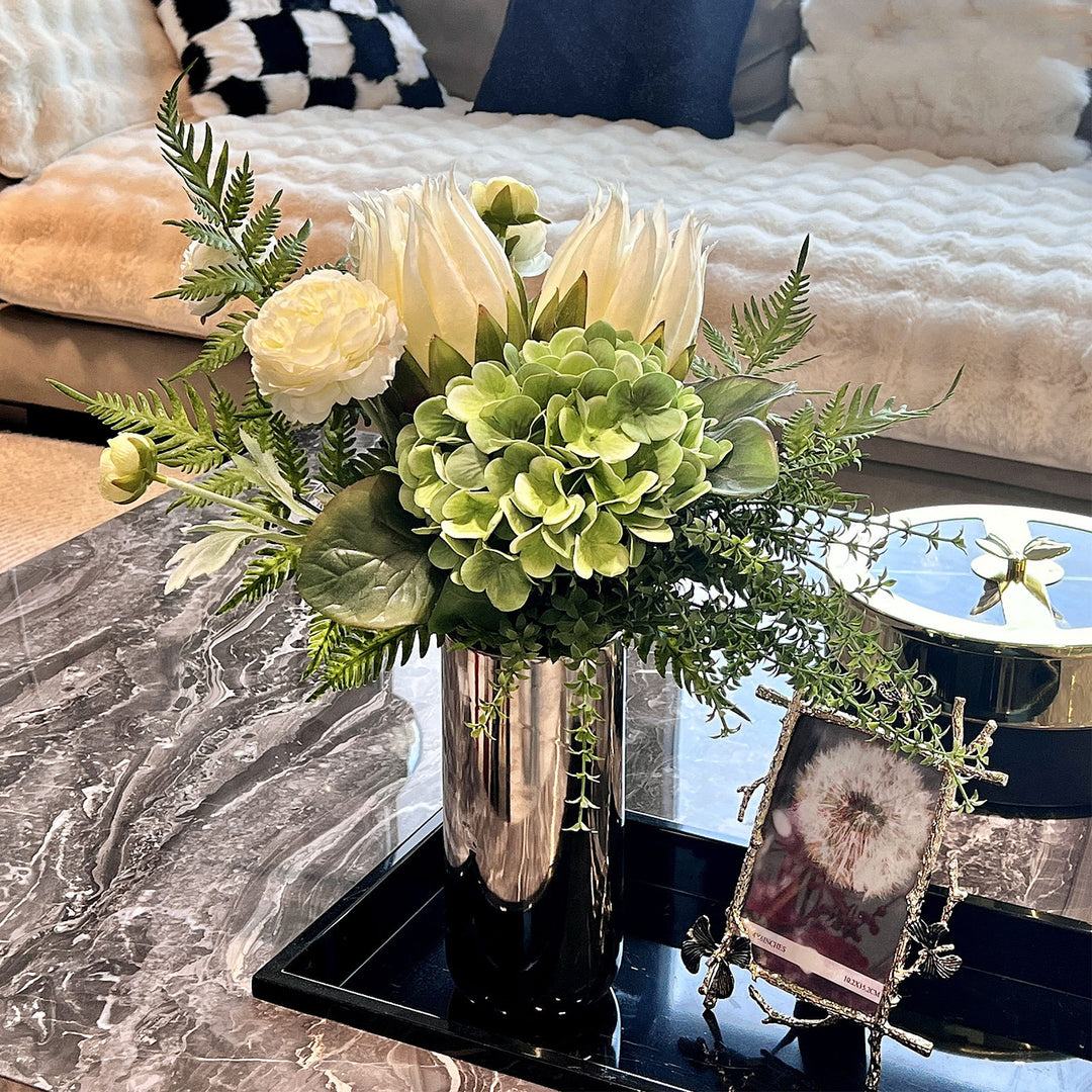 Spiegelnde hohe zylindrische dekorative Metallvase mit künstlicher Hortensie und Protea Arrangement