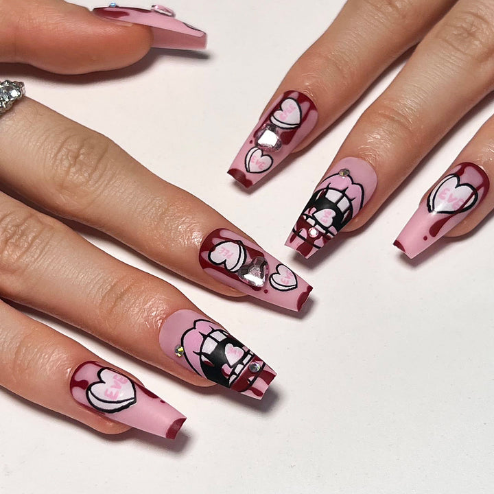 Kunstvolle Stiletto-Nägel mit Herzen und Glitzerakzenten Karnz