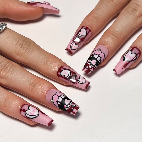 Kunstvolle Stiletto-Nägel mit Herzen und Glitzerakzenten Karnz