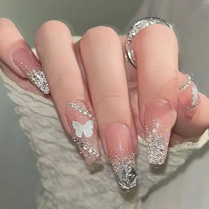 Kunstnagelset mit eleganten Glitzerverzierungen und schimmernden Akzenten Karnz