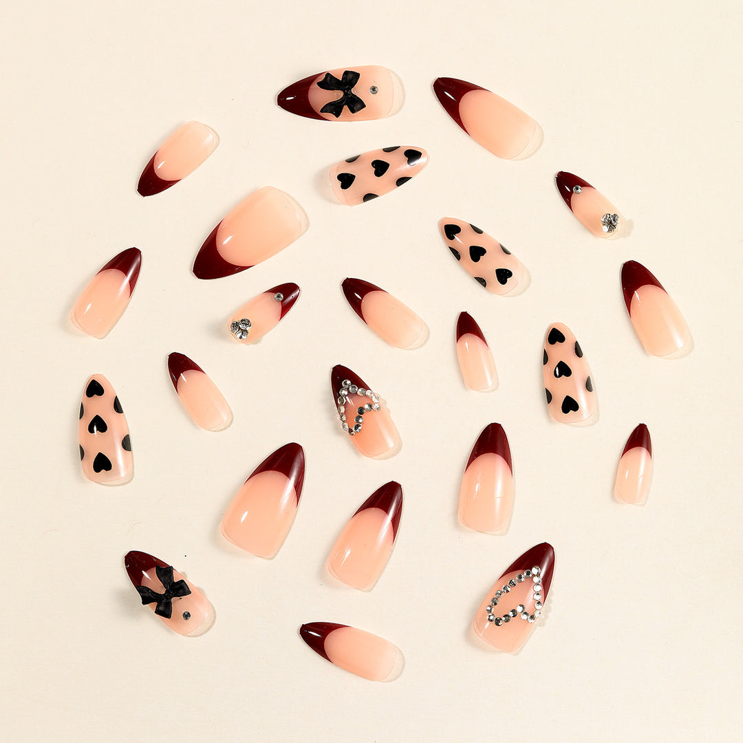 Künstlerische Stiletto-Nagelverlängerungen mit Herz- und Schleifenakzenten Karnz
