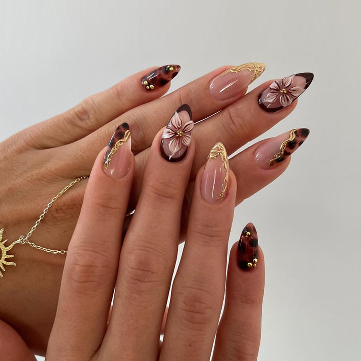 Dekorative Stiletto Press-On Nägel mit floralen und goldenen Akzenten Karnz