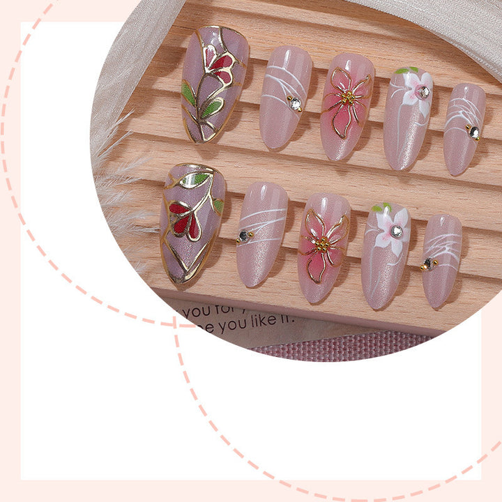 Kunstnagelset mit filigranen floralen Verzierungen und glänzenden Details Karnz