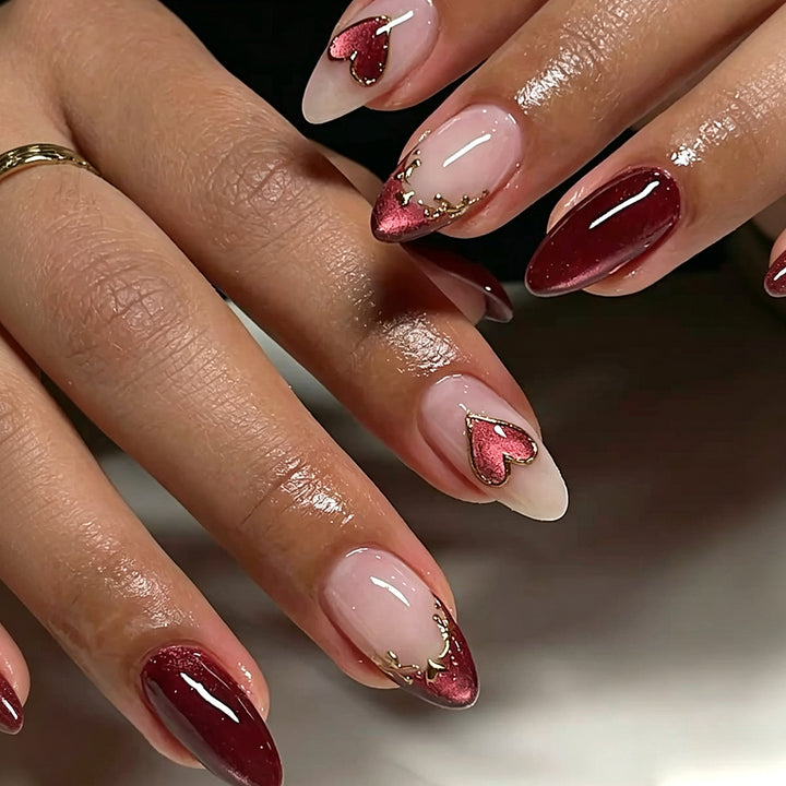 Kunstvolle Stiletto-Nägel mit Herzmotiven und Glitzerverzierung Karnz