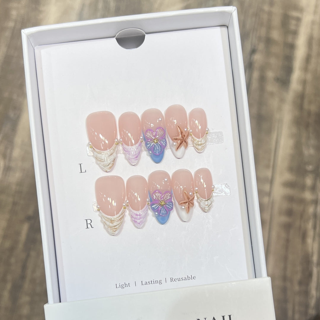 Künstlerisches Press-On Nagelkunst Set mit floralem und Seestern Design Karnz