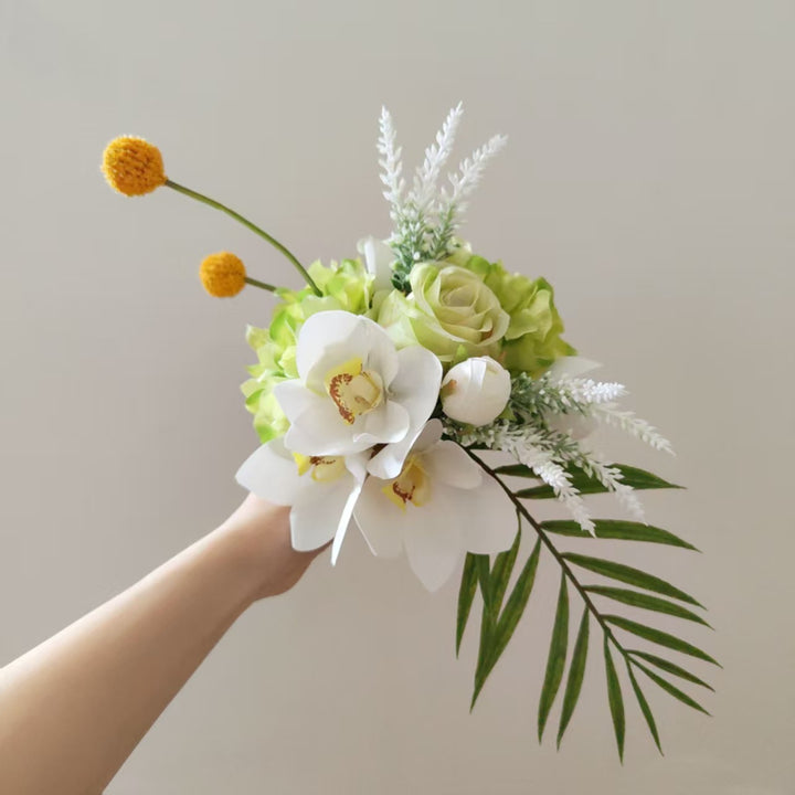 Lebensechte Blumenarrangement mit Orchideen und Grünpflanzen
