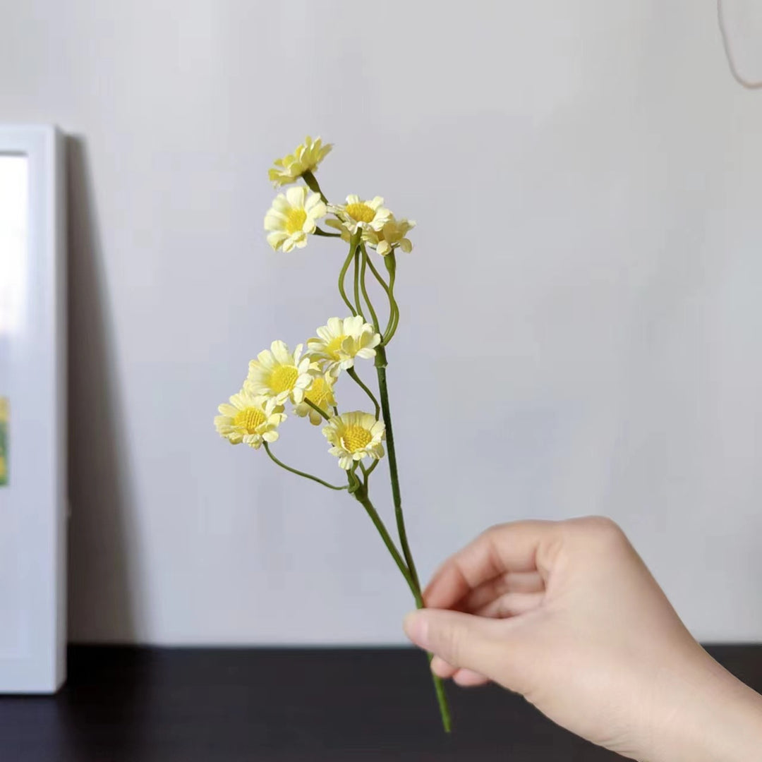Lebensnahe Blumenstange mit charmanten gelben Gänseblümchen