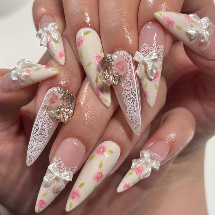 Kunstvolle Stiletto-Nägel mit floralen Akzenten und Glitzerakzenten Karnz