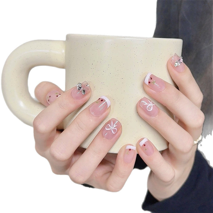 Dekorative Press-On-Nagelkunst mit floralen und Schleifenakzenten