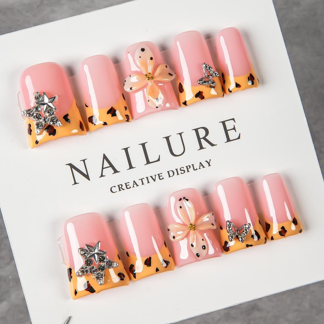 Dekoratives Press-On Nagelset mit floralen und Schmuckakzenten