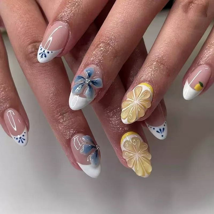 Kunstvolle Kunstnägel mit floralen und fruchtigen Akzenten Karnz
