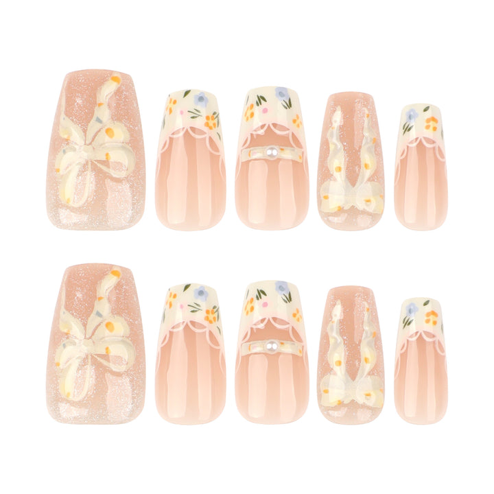 Kunstvolle Nagelverlängerungen mit floralem Design und Schleifenakzenten Karnz