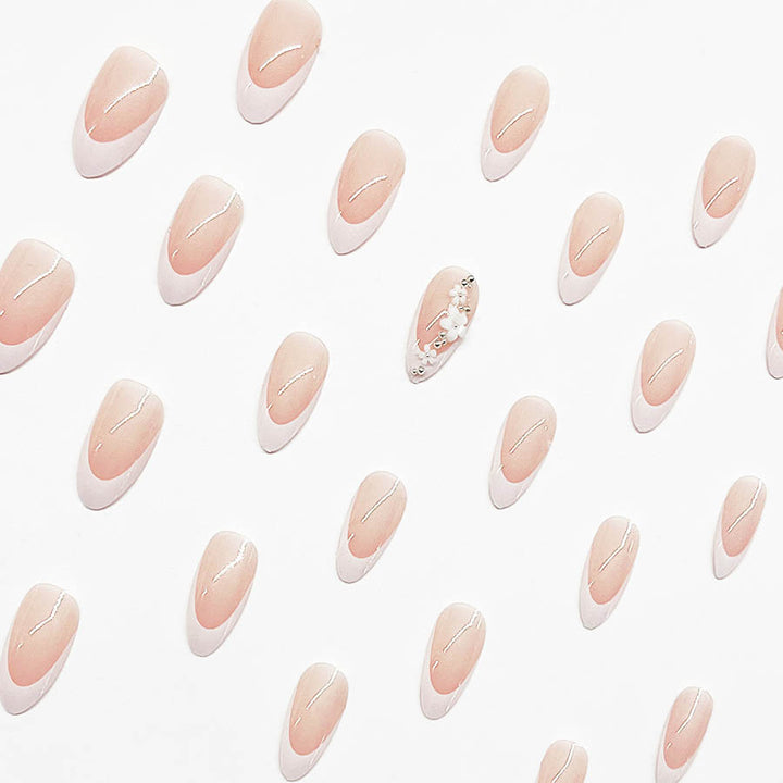 Kunstnagelset mit filigranen Blütenverzierungen und elegantem French Design Karnz