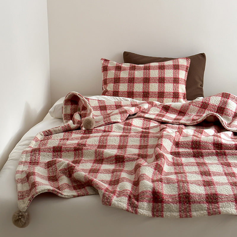 Kuscheldecke mit kariertem Muster und Bommelverzierung Karnz