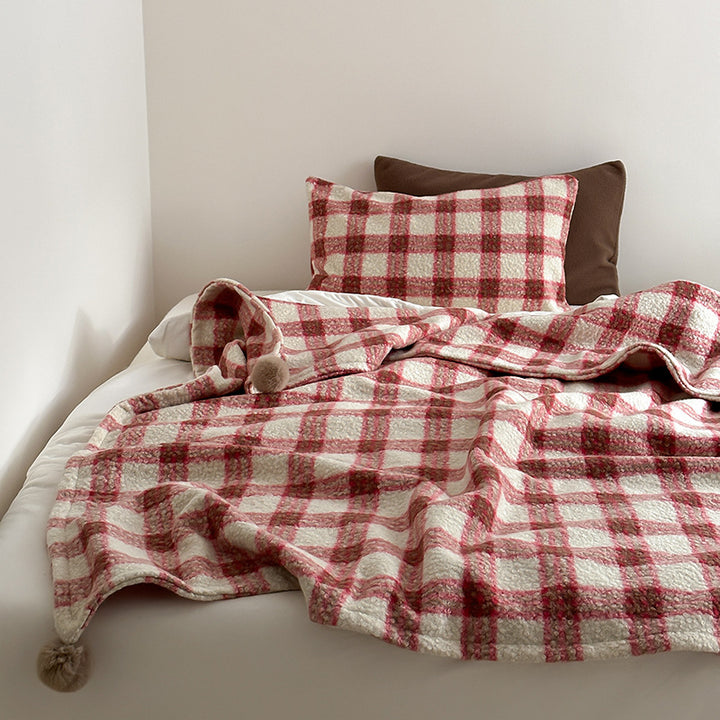 Kuscheldecke mit kariertem Muster und Bommelverzierung Karnz