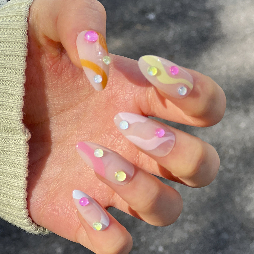 Kunstvolle Nagelverlängerungen mit buntem Design und Glitzerakzenten Karnz
