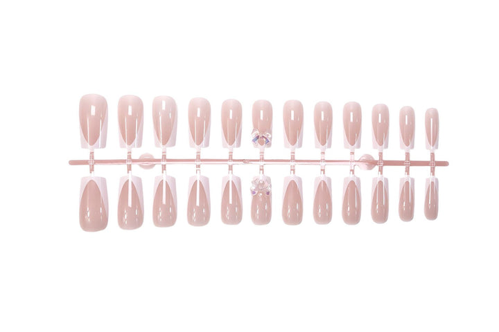 Kunstnagelset mit luxuriösen French-Tipps und eleganten Schmuckverzierungen Karnz