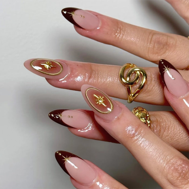 Kunstvolle Stiletto-Nägel mit eleganten Goldverzierungen Karnz