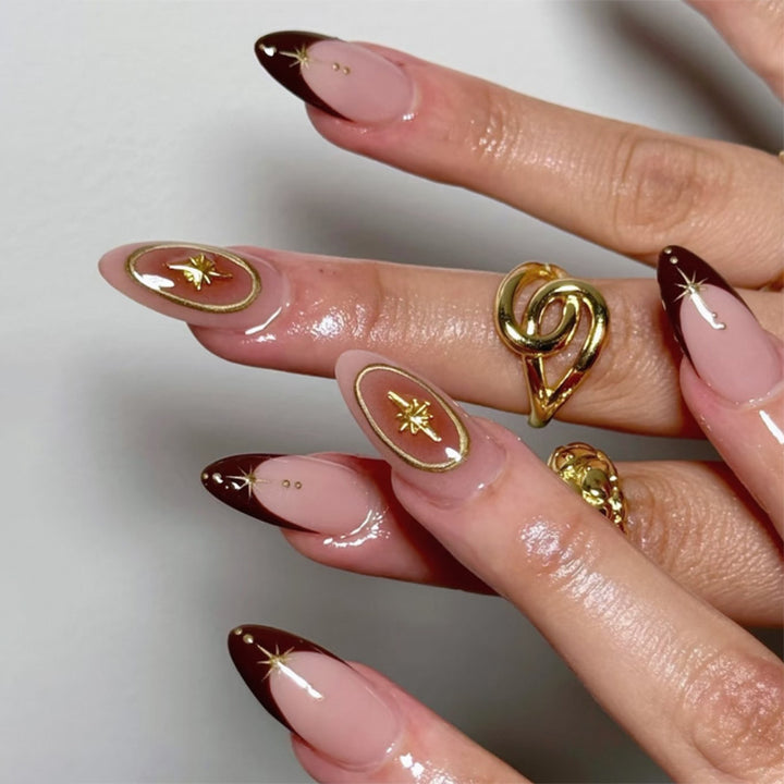 Kunstvolle Stiletto-Nägel mit eleganten Goldverzierungen Karnz