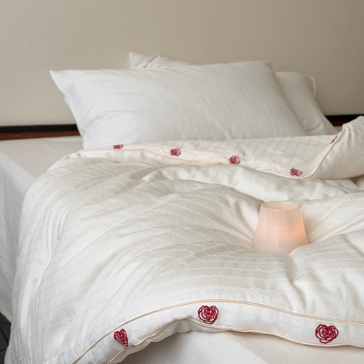 Steppbett aus Baumwollsatin mit gestickter Rosenborte