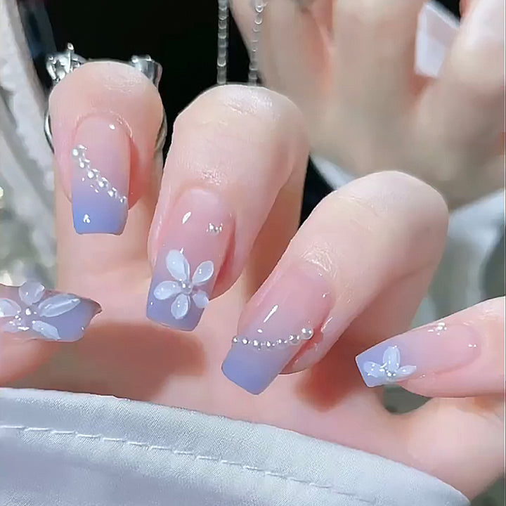 Kunstnagelset mit eleganten blühenden Verzierungen und zartem Ombre-Effekt Karnz
