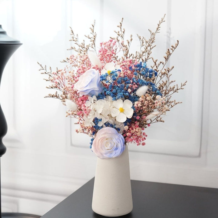 Künstliches Blumenarrangement mit dekorativer Vase
