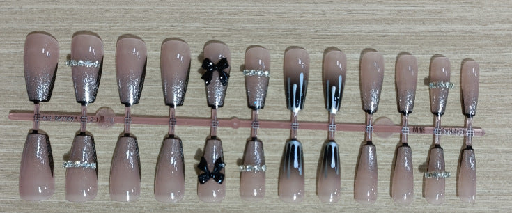 Elegantes Nageldesign mit Schleifen- und Strassdetails Karnz