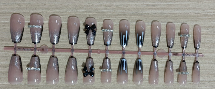 Elegantes Nageldesign mit Schleifen- und Strassdetails Karnz