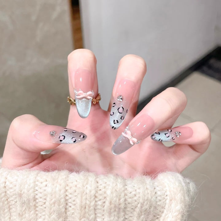 Künstlerische Stiletto Press-On-Nagelset mit Leopardenmuster und Schleifenakzenten Karnz