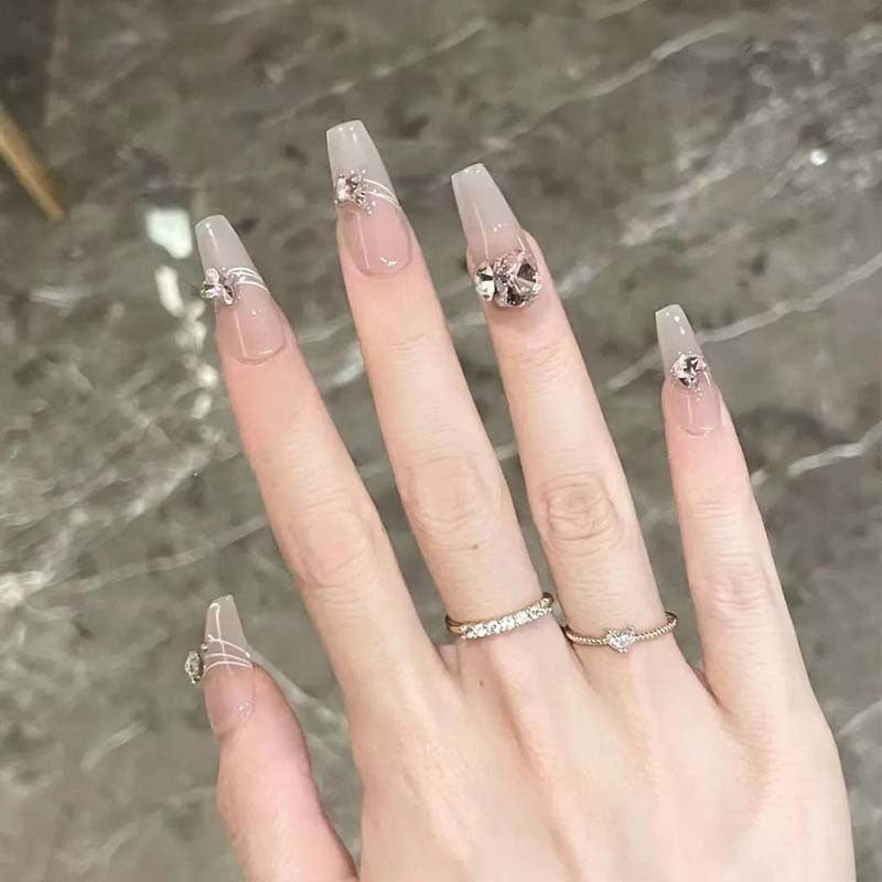Kunstnagelset mit filigranen Verzierungen und glamurösen Akzenten Karnz