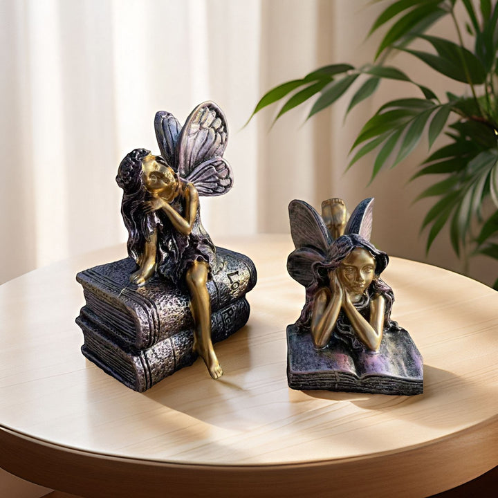 Feenfigurine, die auf Büchern sitzt, Karnz