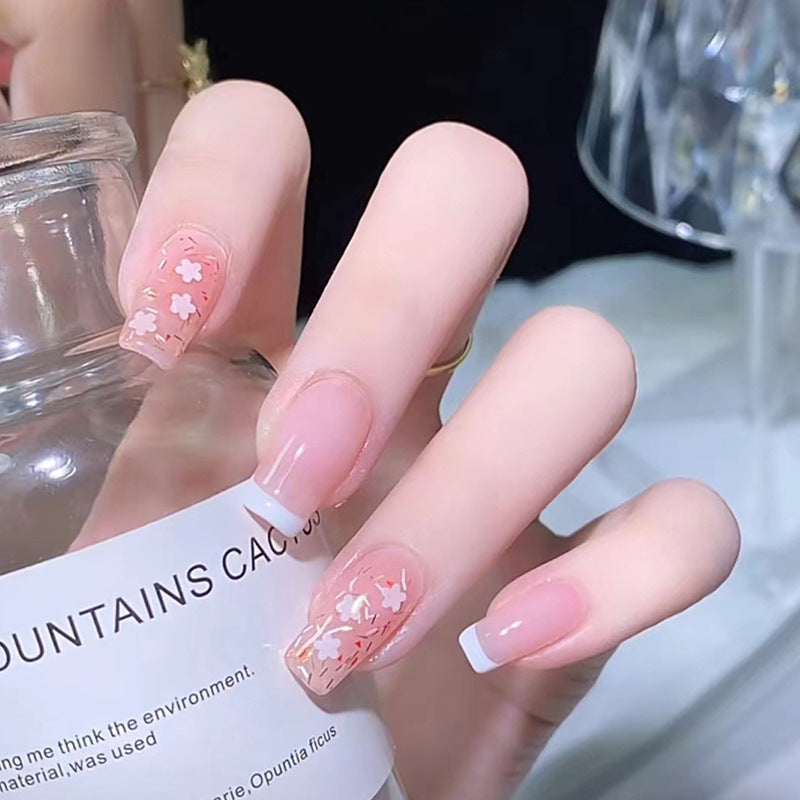 Kunstnagelset mit floralen Verzierungen und elegantem französischen Design Karnz