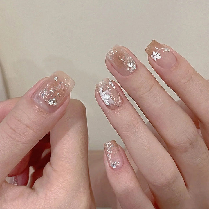 Elegante Nagelkunst mit holografischen Akzenten und floralen Verzierungen Karnz